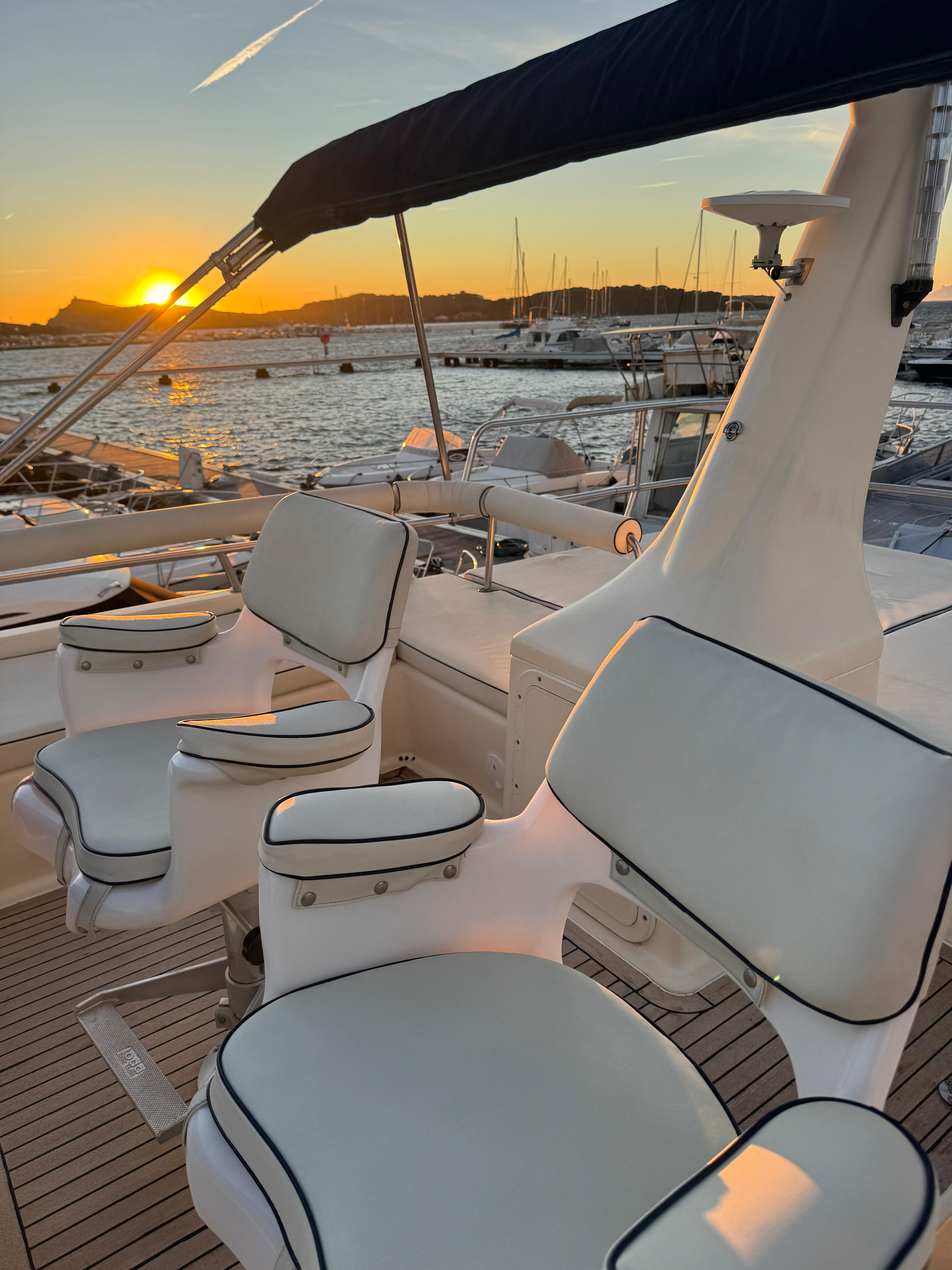 Cockpit d'un voilier au coucher du soleil, sièges en cuir blanc